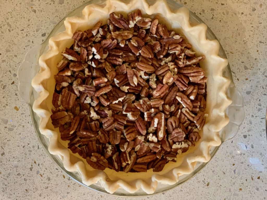 Toasted nuts in an unbaked pie shell to make a Beautiful Pecan Pie.
