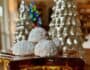 Russian Teacakes displayed with a lit Christmas Tree in the background.