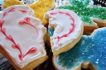 Sugar Cookies, one decorated as a broken heart with Royal Icing and butterfly cookies with decorator sugar.