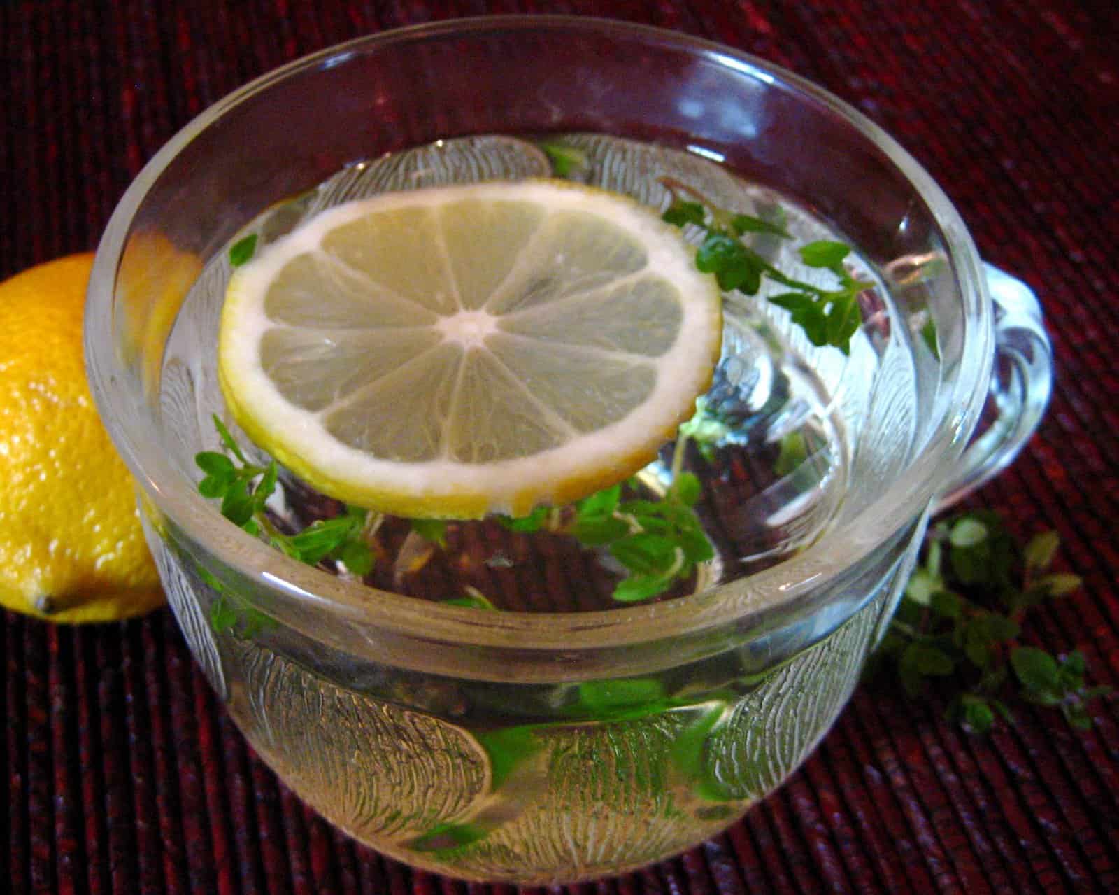 Lemon Thyme Lift Tea in a glass cup with a lemon slice on top