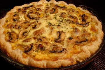 A whole Mushroom and Brie Quiche in a pie dish.