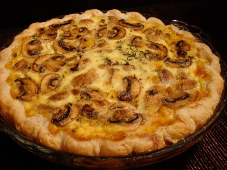 A whole Mushroom and Brie Quiche in a pie dish.