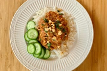 Thai Chicken Thighs, sprinkled with peanuts and cilantro served over Coconut Rice with a side of Cucumber Vinaigrette.