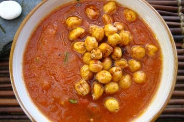 A bowl of freshly made Gazpacho topped with Saffron Roasted Chickpeas in a ceramic bowl.