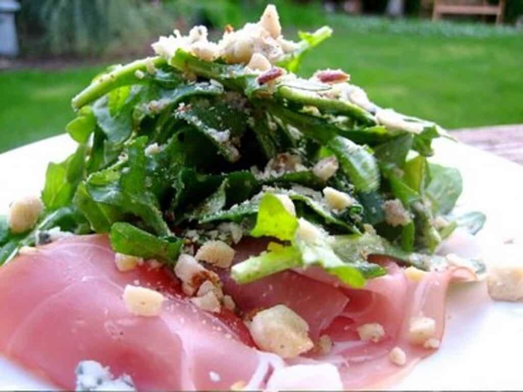 An Arugula Salad with cured ham, hazelnuts and blue cheese. 