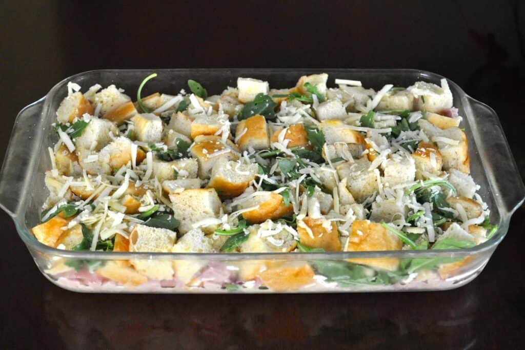 Arugula and Ham Strata assembled in a 9"x13" casserole and ready to bake.