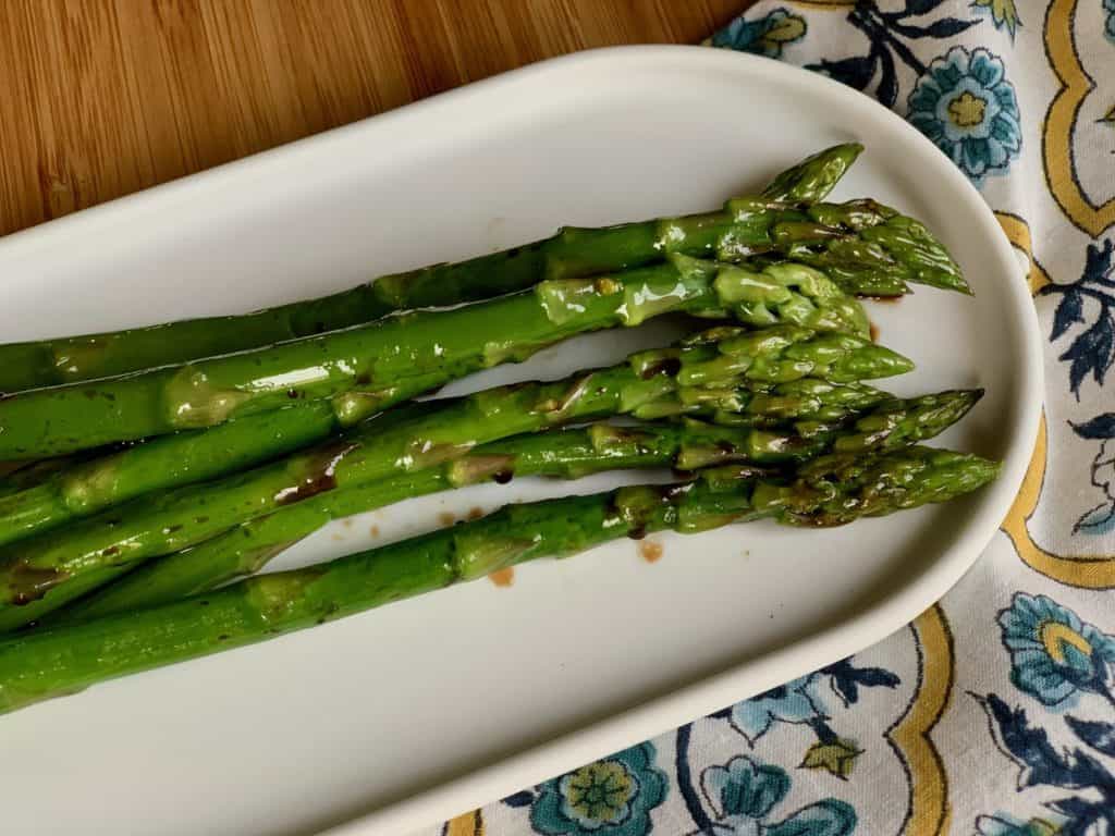 Roasted Asparagus with Balsamic Vinegar on an oval white serving dish.