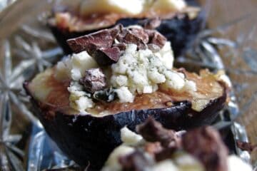 Figs stuffed with Blue Cheese and Cacao Nibs served on a glass tray.