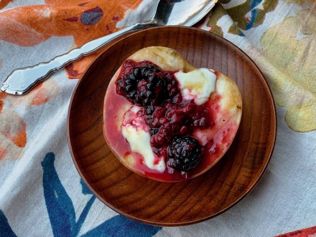 A grilled peach half filled with creamy mascarpone and topped with luscious Basil Berry Sauce.