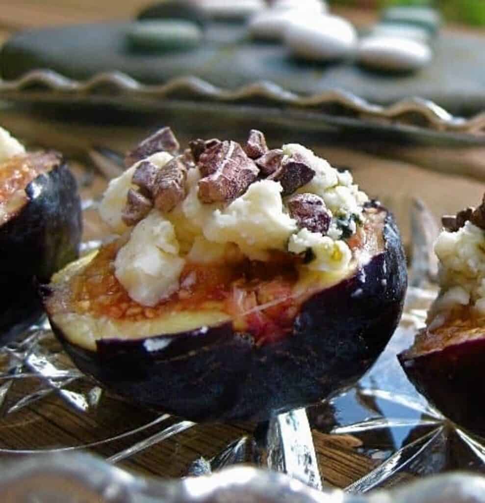 Halved Figs stuffed with blue cheese and sprinkled with cacao nibs served on the deck.