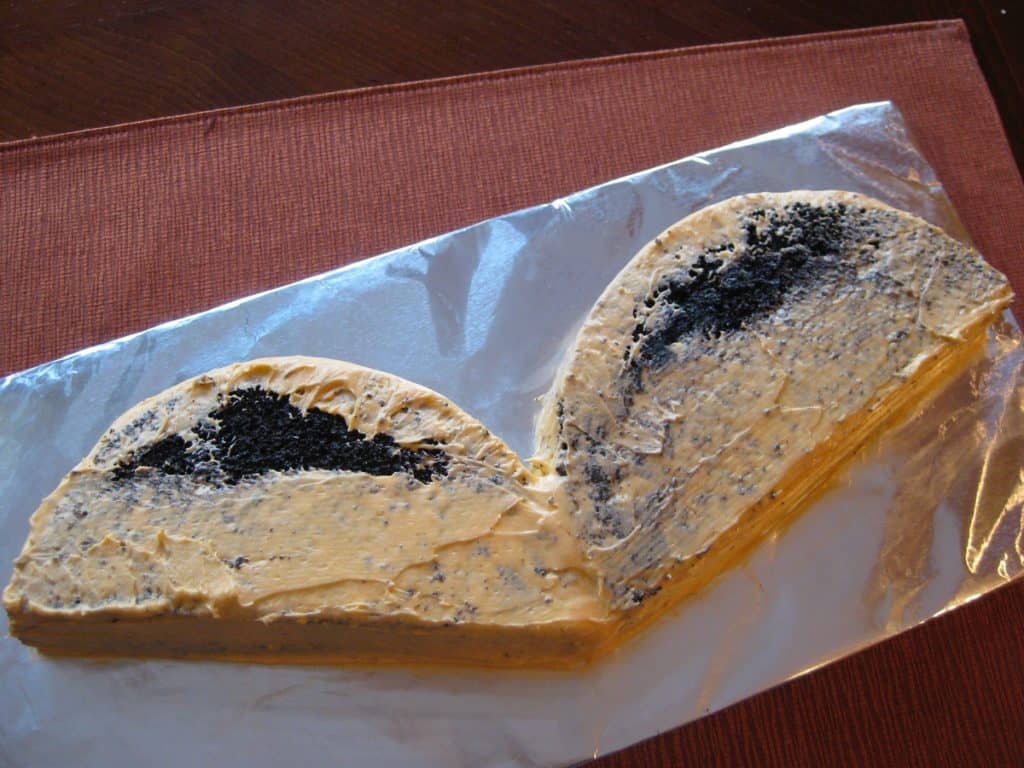 Halloween Vampire Bat Cake wings covered in crumb coat of frosting.