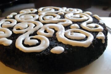 The Easiest Less-Mess Chocolate Cake topped with swirls of Icing.