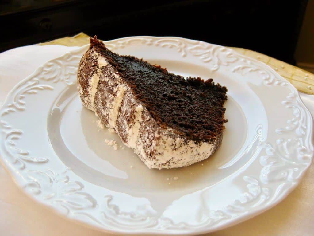 A Slice of Bourbon Chocolate Cake on a white dessert plate. 