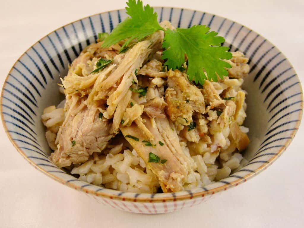 Maple Glazed Pulled Pork over Rice garnished with a sprig of cilantro.