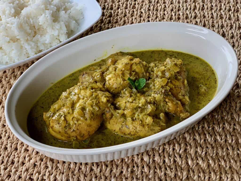 Saucy Slow-Cooked Green Chicken Masala is garnished with a mint leaf.