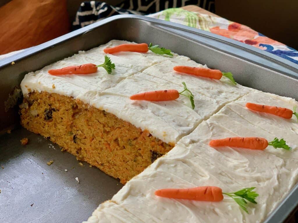 Carrot Cake baked in a 9 x 13-inch pan and topped with cream cheese frosting and cream cheese carrots.