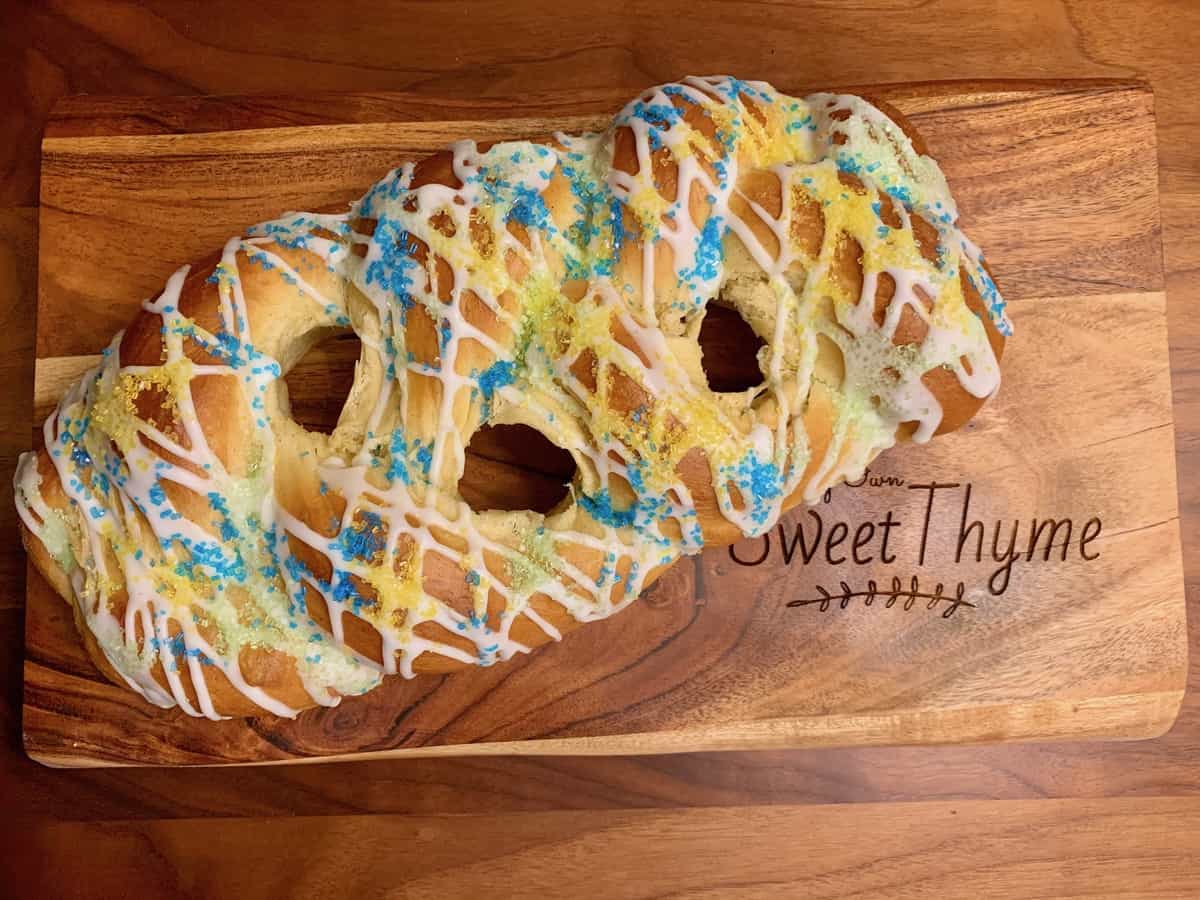 A Cardamom Citrus Easter Braid drizzled with Lemon Icing, before colored Easter eggs are inserted.