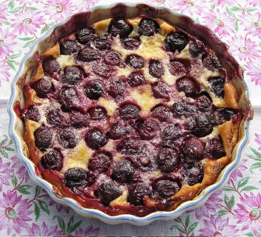 Whole Cherry Clafouti in serving dish on vintage cloth