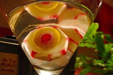 Radish Eyeballs in clear beverage served in a martini glass.