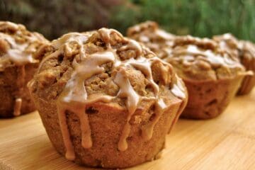 A Pumpkin Spice Latte Muffin drizzled with a Pumpkin Coffee Glaze dripping down the sides.