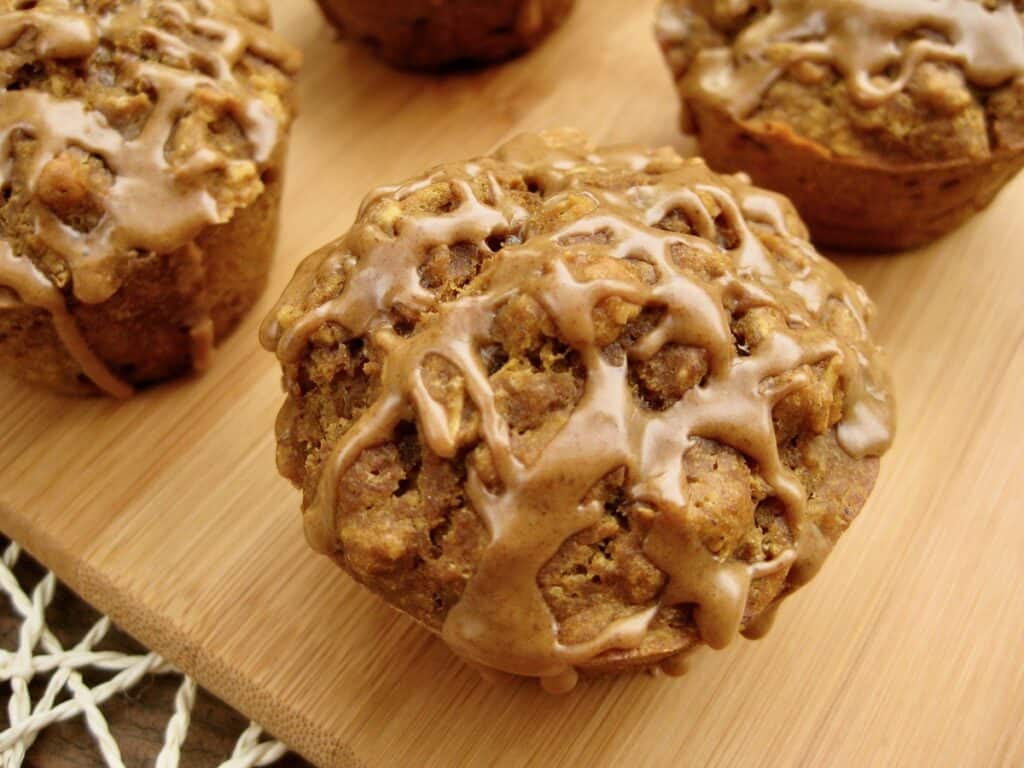 Pumpkin Spice Latte Muffins drizzled with a Pumpkin Coffee Glaze on a serving board.