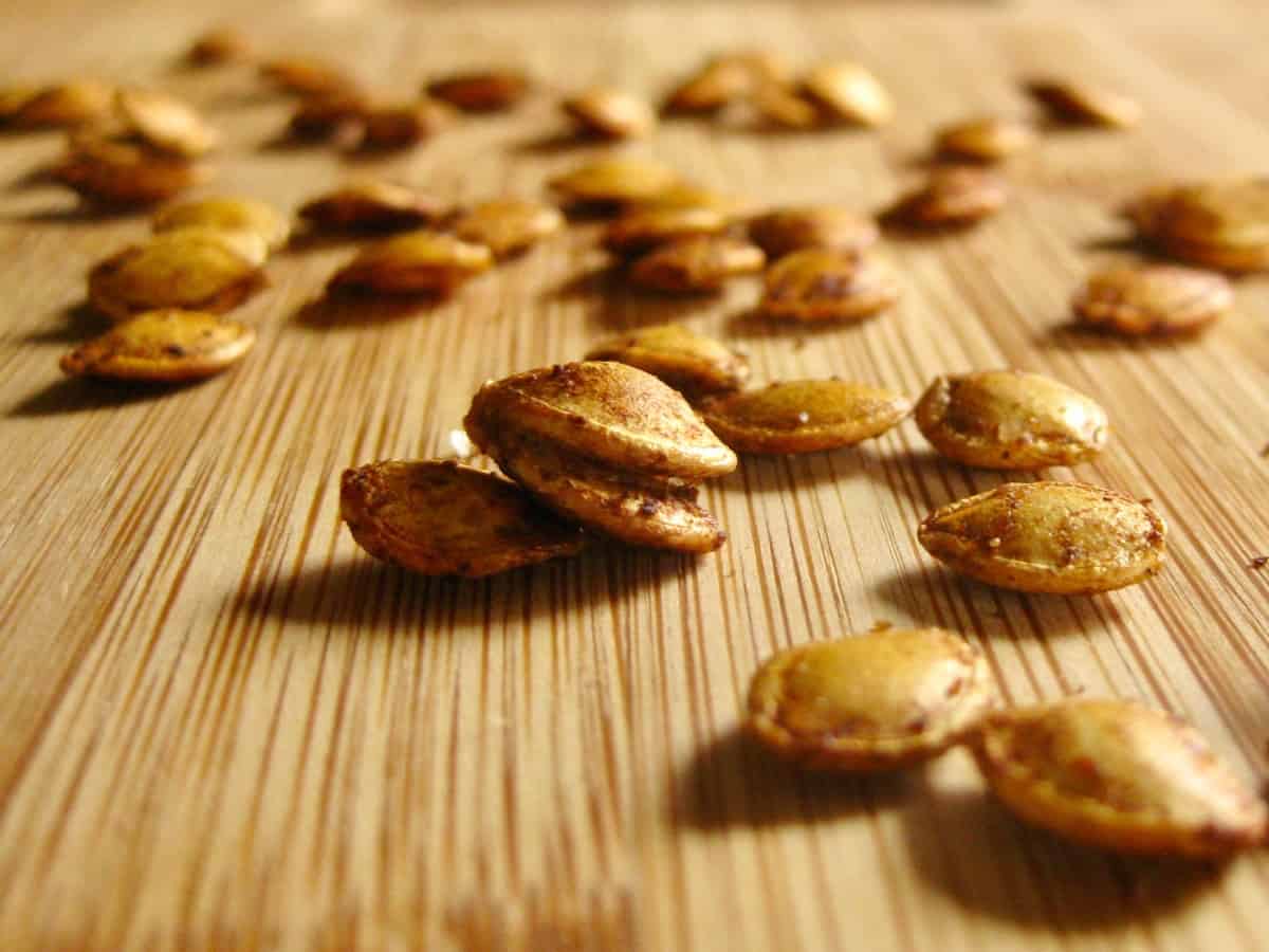 Roasted Delicata Squash Seeds scattered on a wooden board