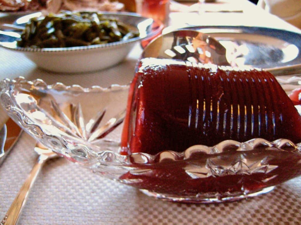 Jellied Cranberry Sauce from a can (with the can marks) served in a cut glass bowl on the Thanksgiving table.