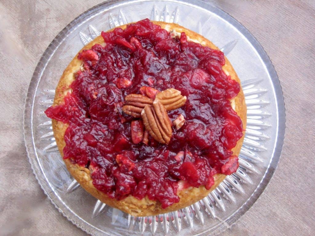 Cranberry Cheesecake Spread with Cranberry Sauce on top and a garnish of pecans, viewed from above.