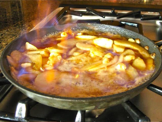 Pear Hazelnut Flambe Sauce in a skillet with flames.