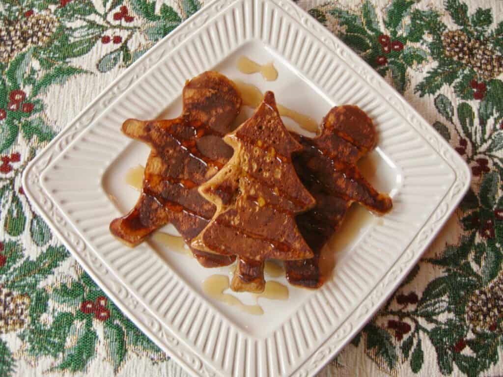 Gingerbread Pancakes cooked in festive shapes and drizzled with syrup.