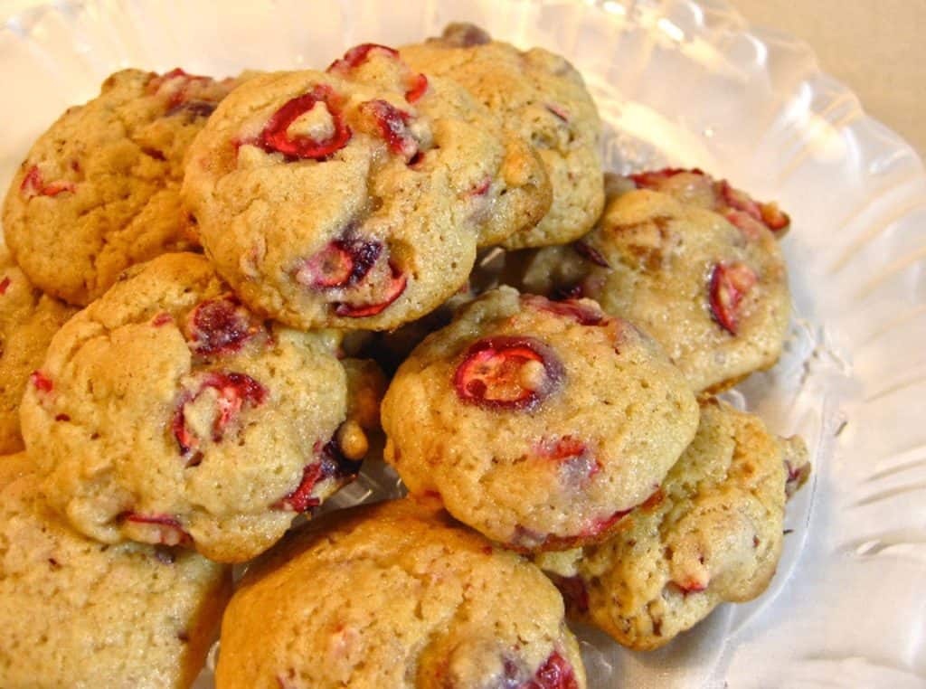 Cranberry Pecan Drop Cookies piled on a glass plate.