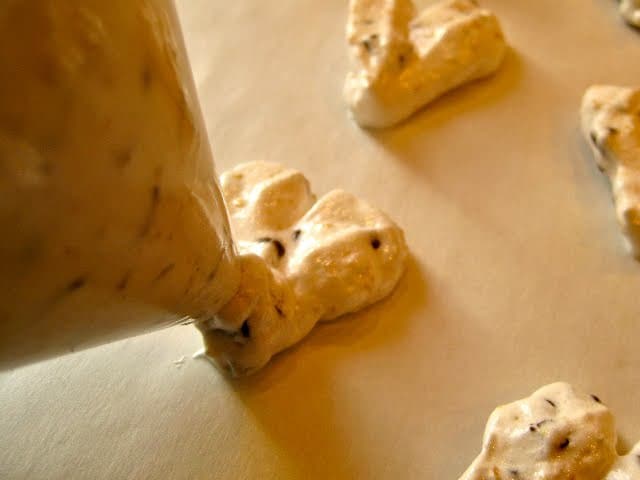 Piping the second half of a heart shaped meringue cookie.
