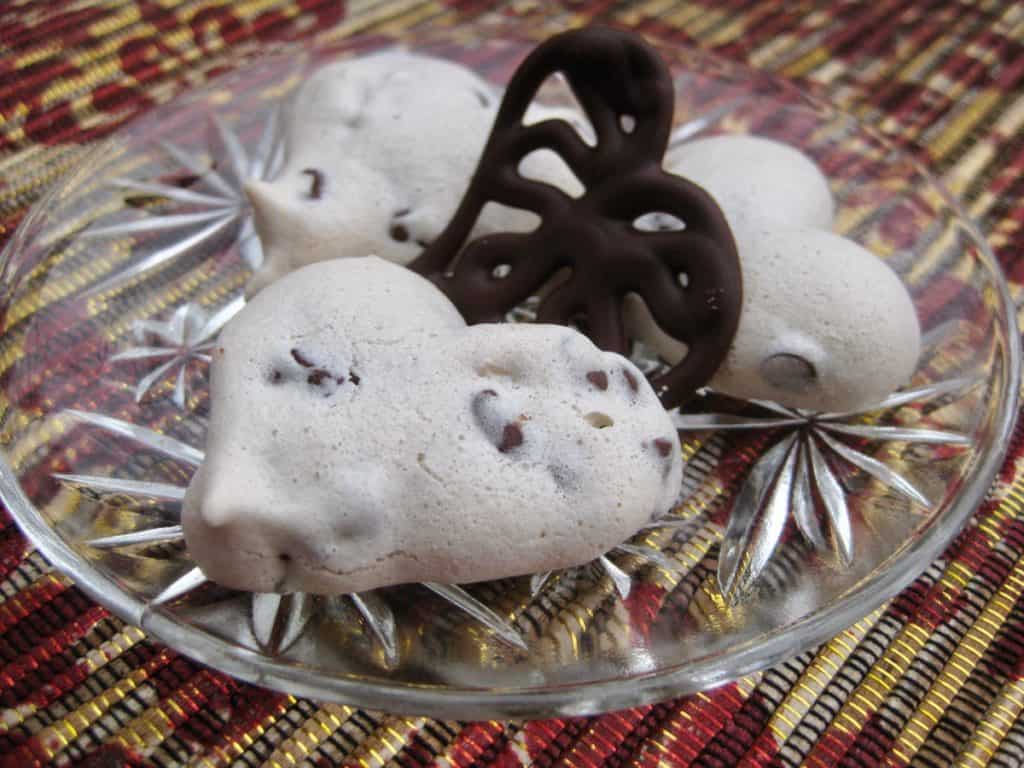 Three Valentine Meringue Heart Cookies with a Filigree Chocolate Heart at the center.