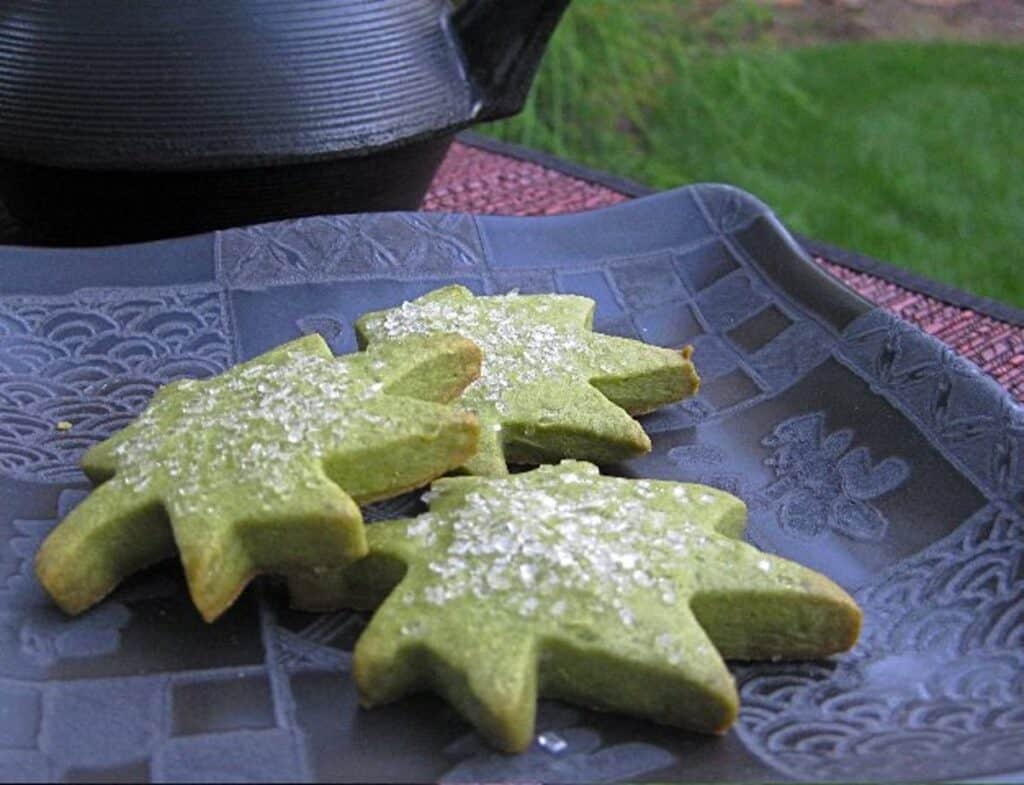 Green Tea Cookies (Matcha Shortbread) served on a square black Japanese plate beside an iron teapot (tetsubin). 