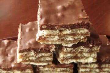 Twickers Bars are stacked on a plate showing their layers of cracker, caramel and delicious topping.