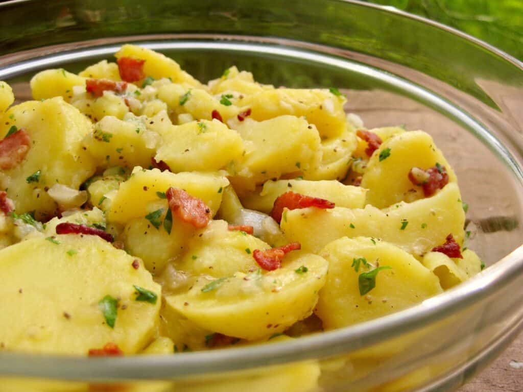 Hot German Potato Salad flecked with bacon, parsley and onion.