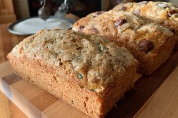 Three loaves of Zucchini Bread on a wood cutting board.