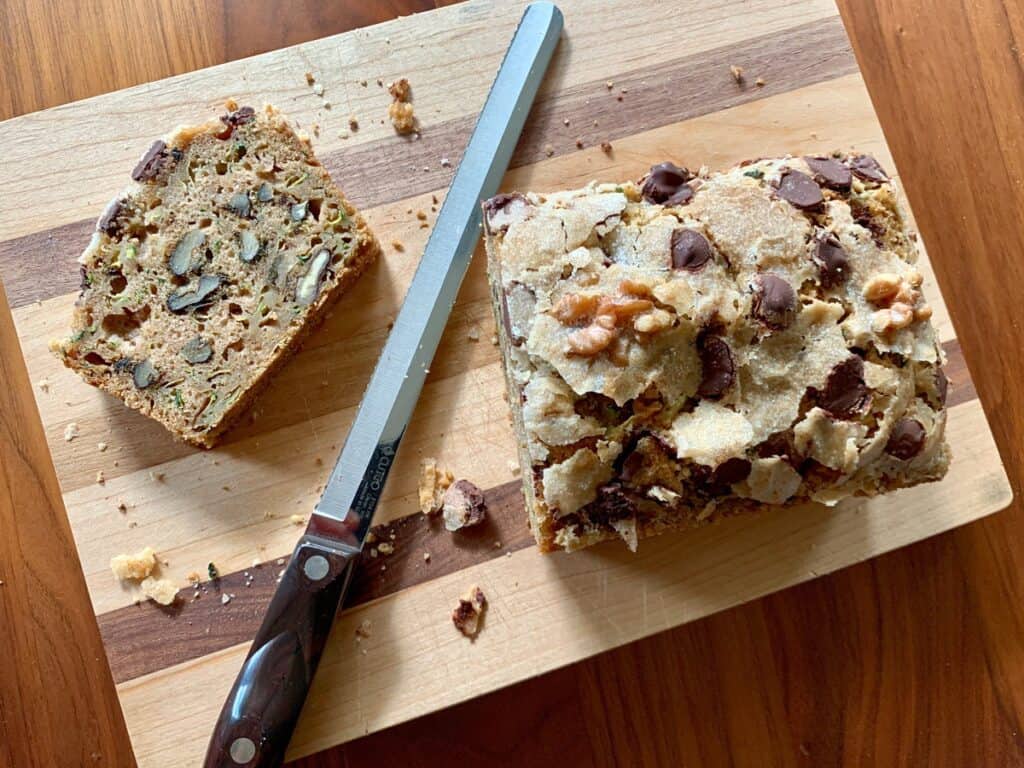 A loaf of Zucchini Bread sliced open on a cutting board.