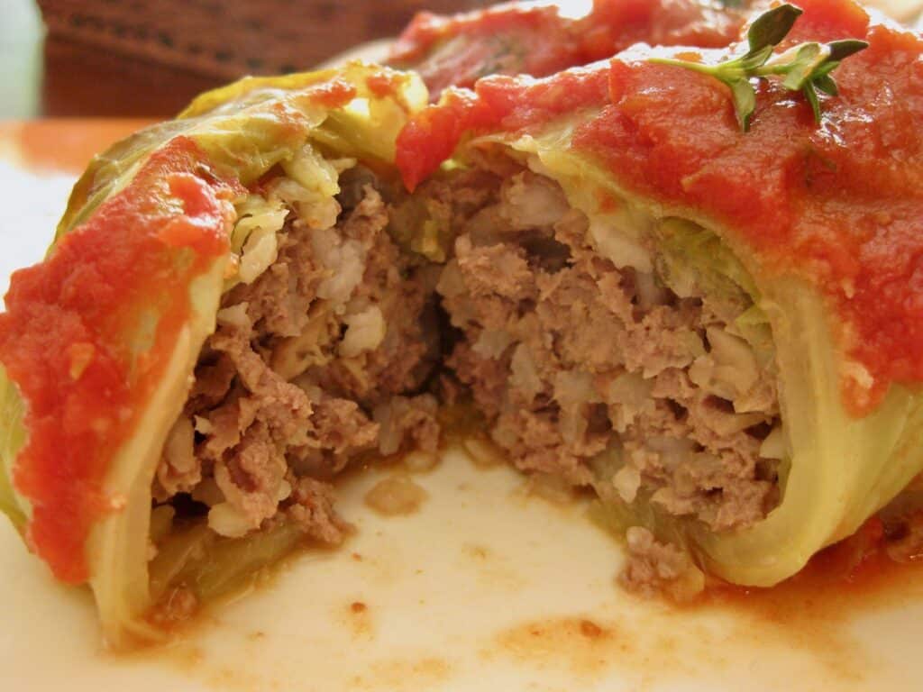 The filling of a cabbage roll from Gram's Galumpki is on display beneath a tomato sauce topping with a sprig of thyme.