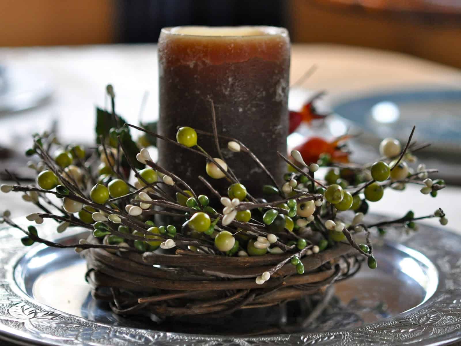 A pillar candle in an autumn wreath from the Thanksgiving Table.