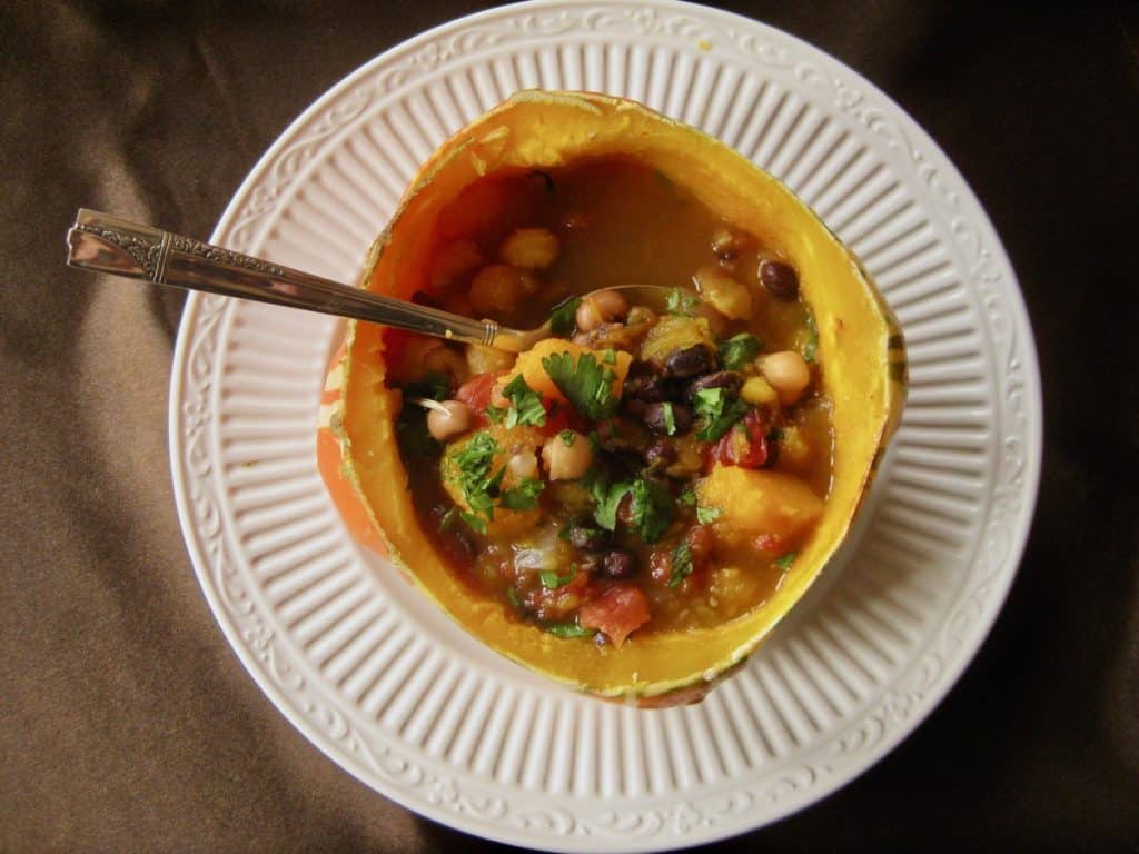 Squash and Hominy Stew served in a bowl made from squash viewed from overhead.