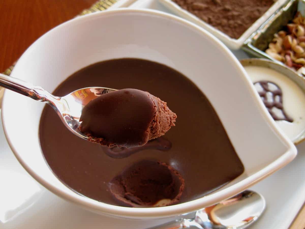 Chocolate Ganache being scooped from a bowl before rolling in cocoa powder.