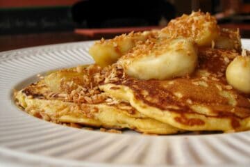 Sweet Potato Pancakes stacked Coconut Banana Topping on a plate.