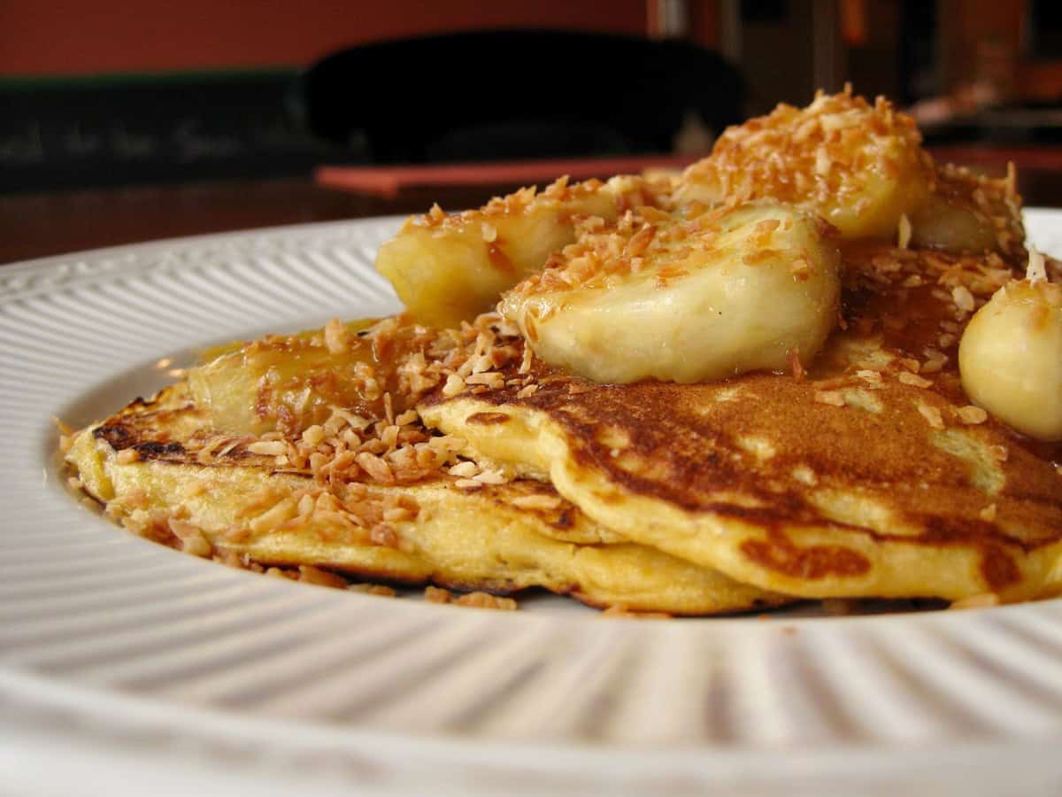 Sweet Potato Pancakes stacked Coconut Banana Topping on a plate.