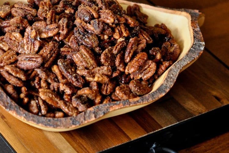 Bourbon Spiced Pecans served in a natural wooden bowl