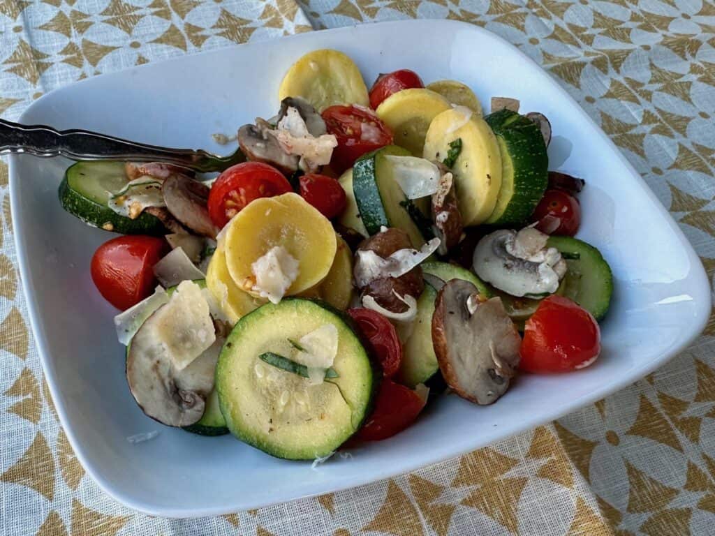 Summer squash and fresh tomatoes are tossed with mushrooms herbs and Parmesan cheese in this late summer vegetable medley. 