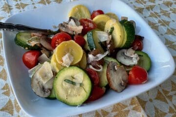 Summer squash and fresh tomatoes are tossed with mushrooms herbs and Parmesan cheese in this late summer vegetable medley.