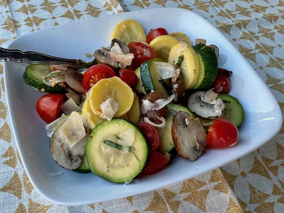 Summer squash and fresh tomatoes are tossed with mushrooms herbs and Parmesan cheese in this late summer vegetable medley.