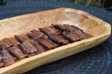Candied Bourbon Bacon Bites served on a wood tray.