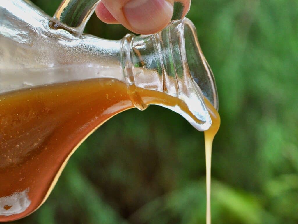 Caramel Sauce is pouring from a small antique pitcher. 